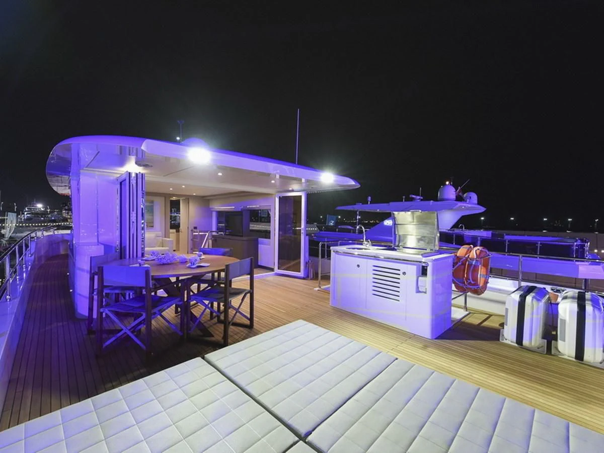 a swimming pool with a table and chairs and a bar aboard NOMAD 70 SUV Yacht for Sale
