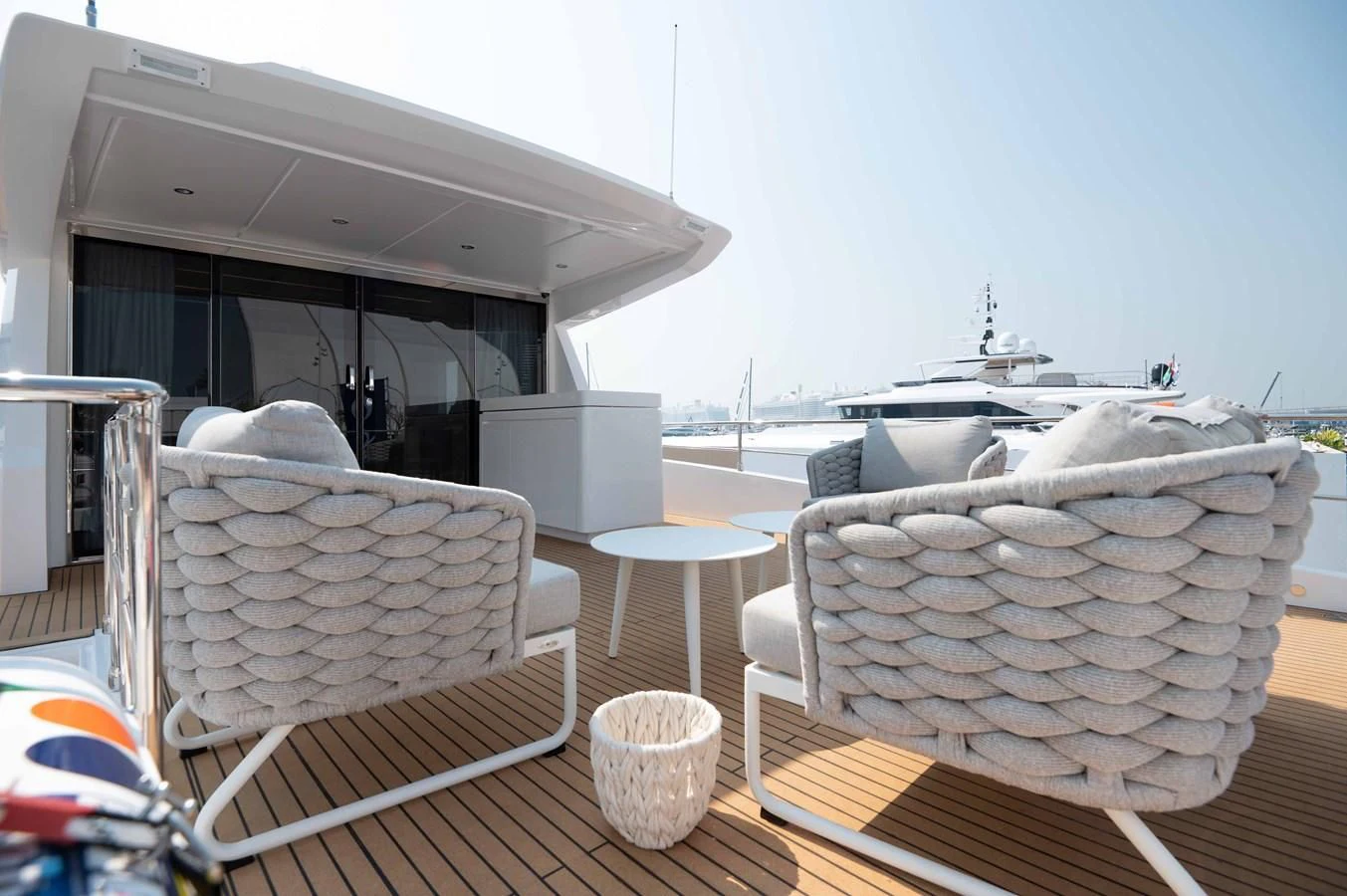 a table with chairs and a white chair on it aboard NOMAD 70 SUV Yacht for Sale