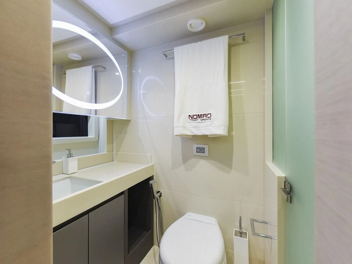 a bathroom with a toilet and a sink aboard NOMAD 70 SUV Yacht for Sale