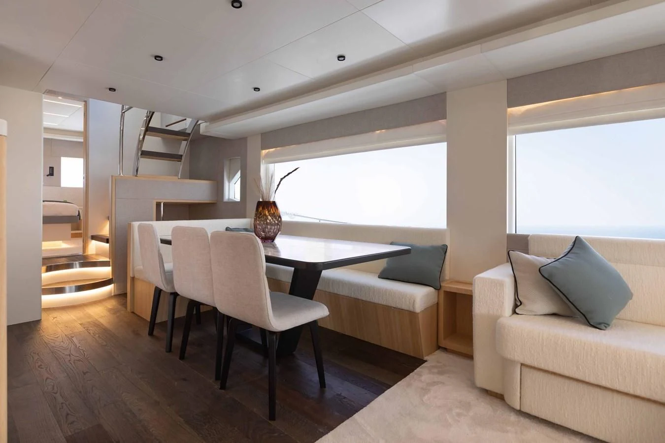 a living room with a table and couches aboard NOMAD 70 SUV Yacht for Sale