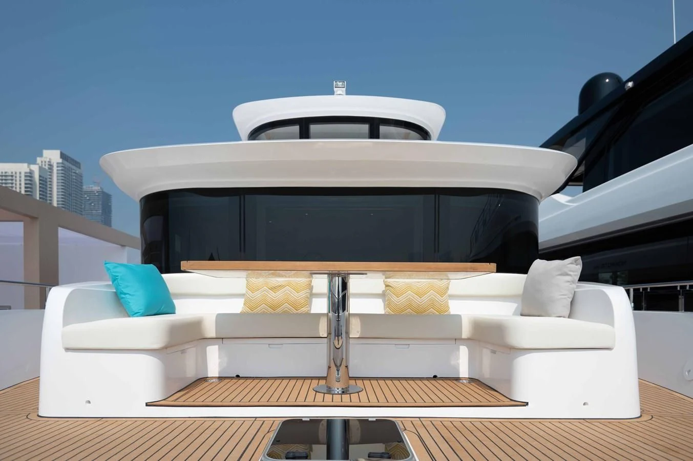 a white couch with a black and white striped pillow on it aboard NOMAD 70 SUV Yacht for Sale