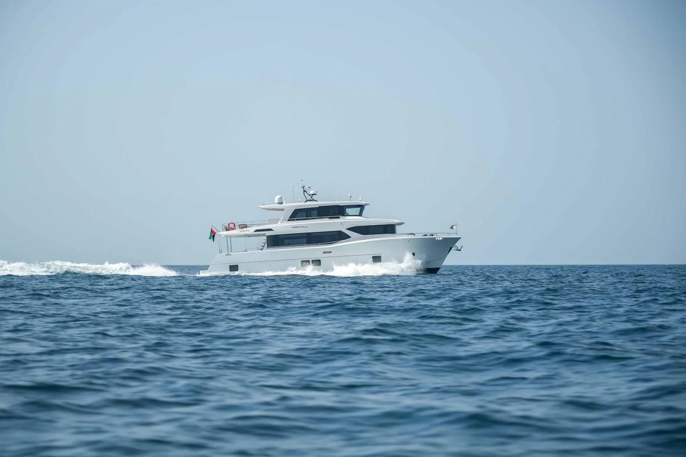 a white yacht in the water aboard NOMAD 70 SUV Yacht for Sale