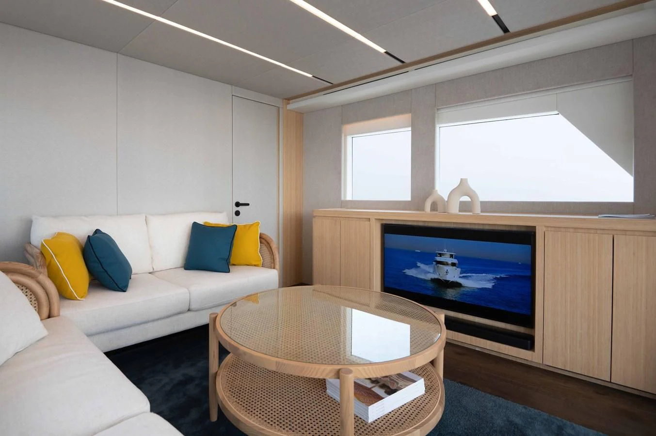 a living room with a television and a table aboard NOMAD 70 SUV Yacht for Sale
