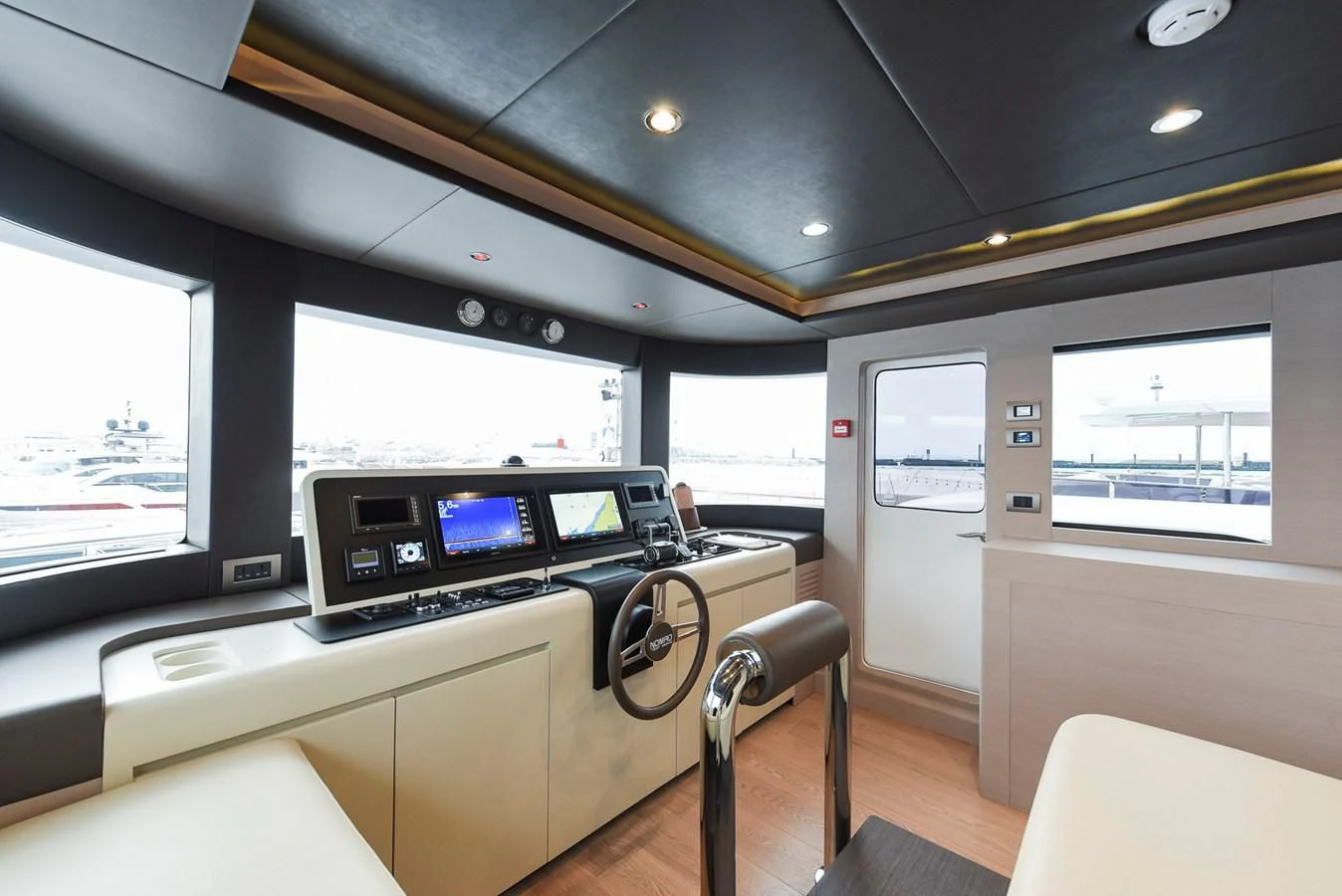 inside of a vehicle with a large screen and a desk with a chair and a window aboard NOMAD 70 SUV Yacht for Sale
