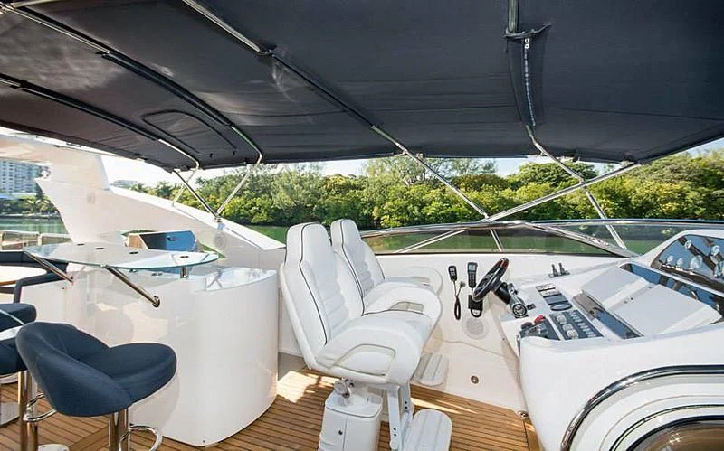 a white table with chairs and a black umbrella on it aboard DELFINO Yacht for Sale