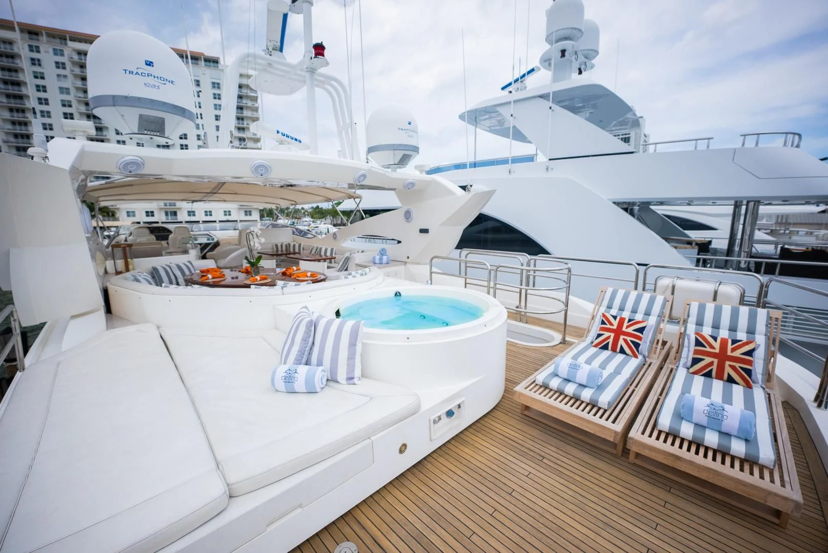 a room with a pool and a deck with boats and a large ship in the background aboard DELFINO Yacht for Sale