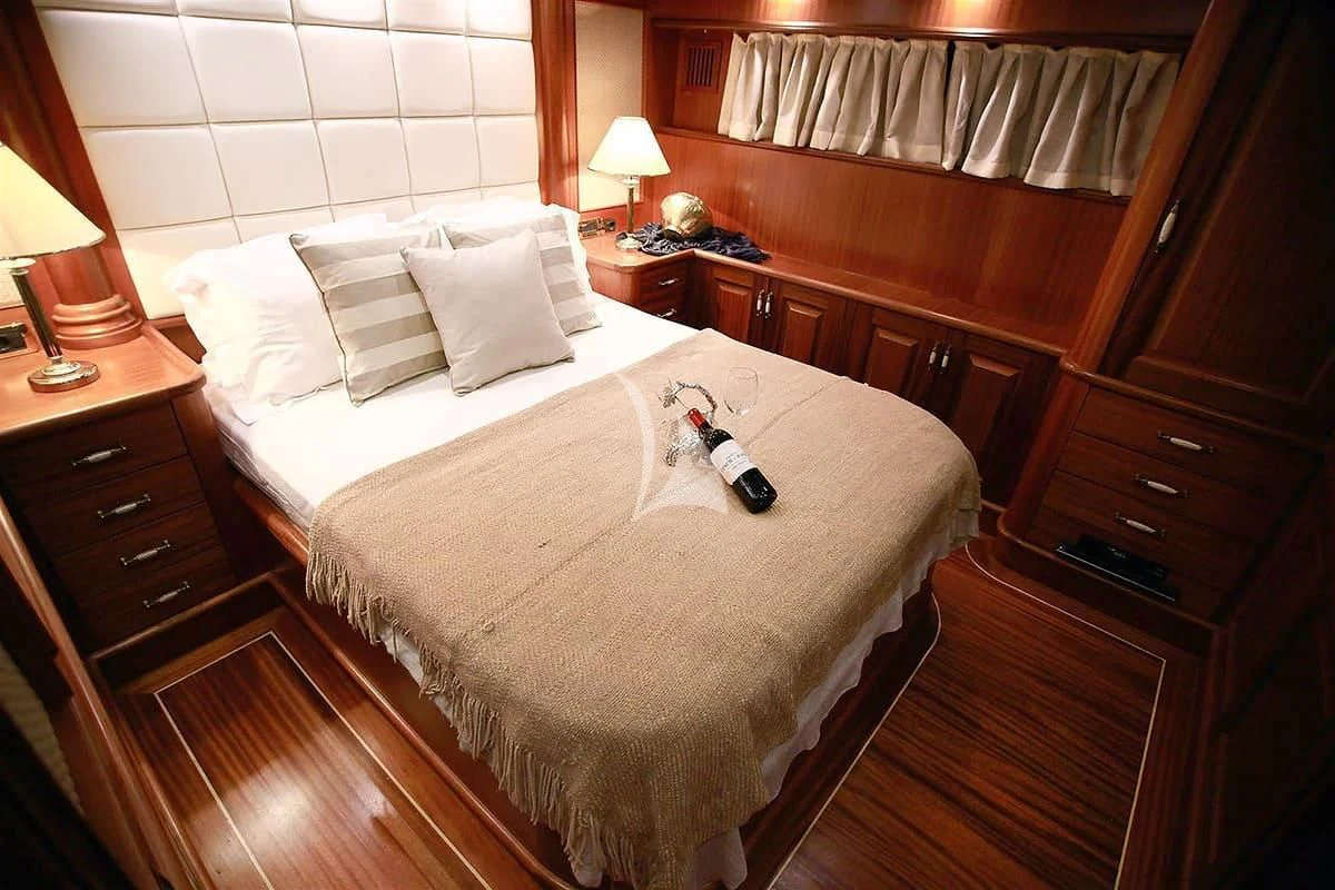 a bed with a bottle of wine on it aboard NURTEN A Yacht for Sale