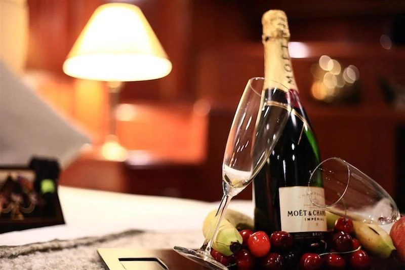 a bottle of champagne and a glass of champagne aboard NURTEN A Yacht for Sale