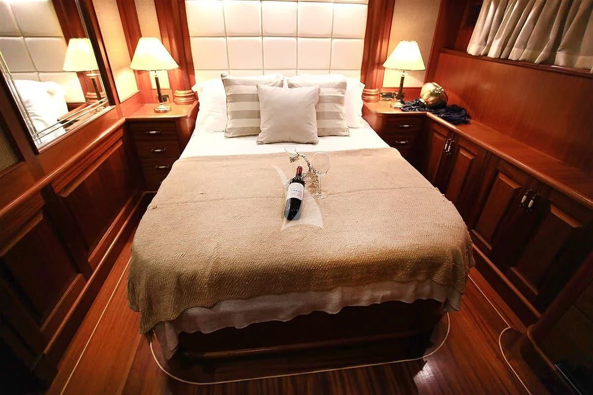 a bed with pillows and a bottle on it aboard NURTEN A Yacht for Sale
