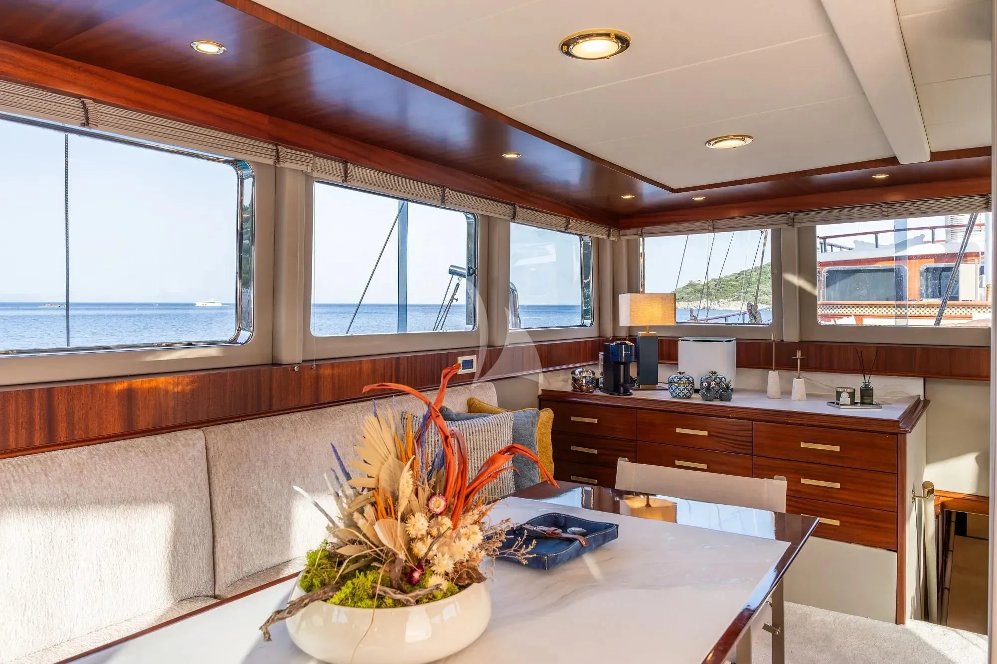 a large kitchen with a large white table and a plant in a pot aboard NURTEN A Yacht for Sale