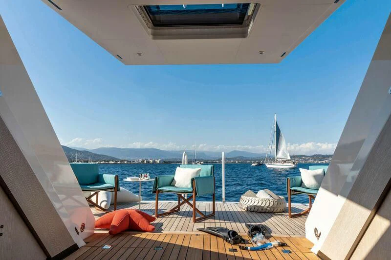 a deck with chairs and a body of water in the background aboard RIO Yacht for Sale