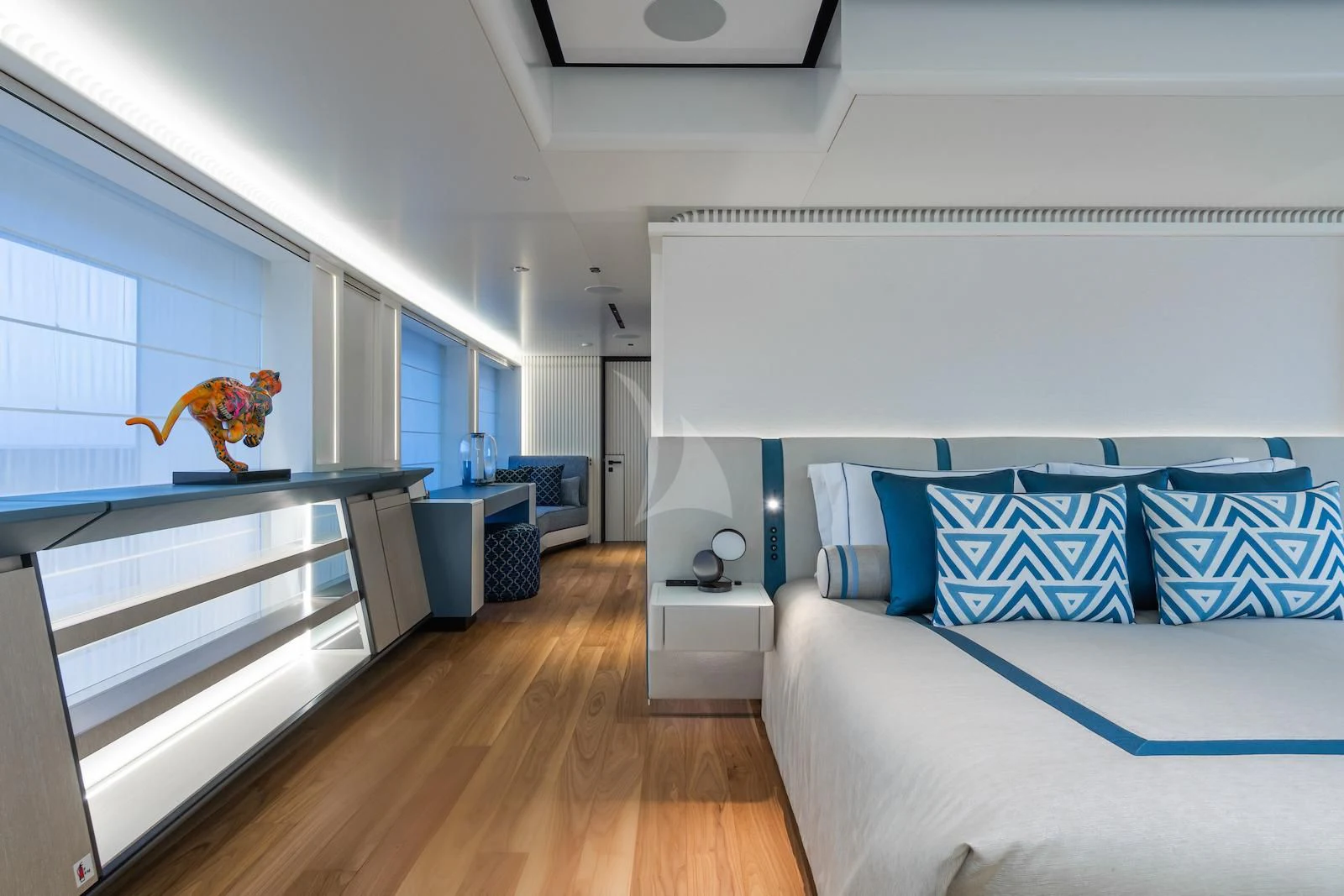 a room with a wood floor and blue and white couches aboard RIO Yacht for Sale