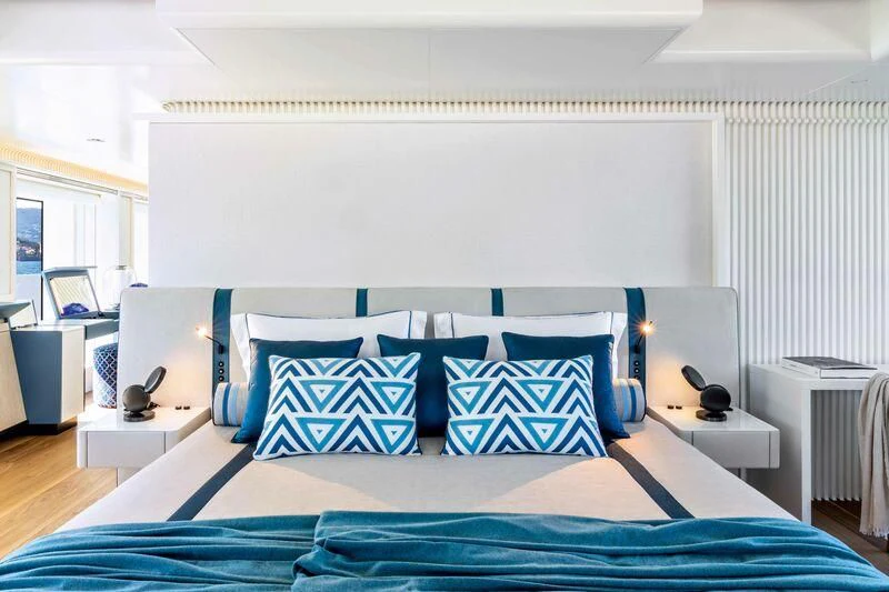 a bed with blue sheets aboard RIO Yacht for Sale