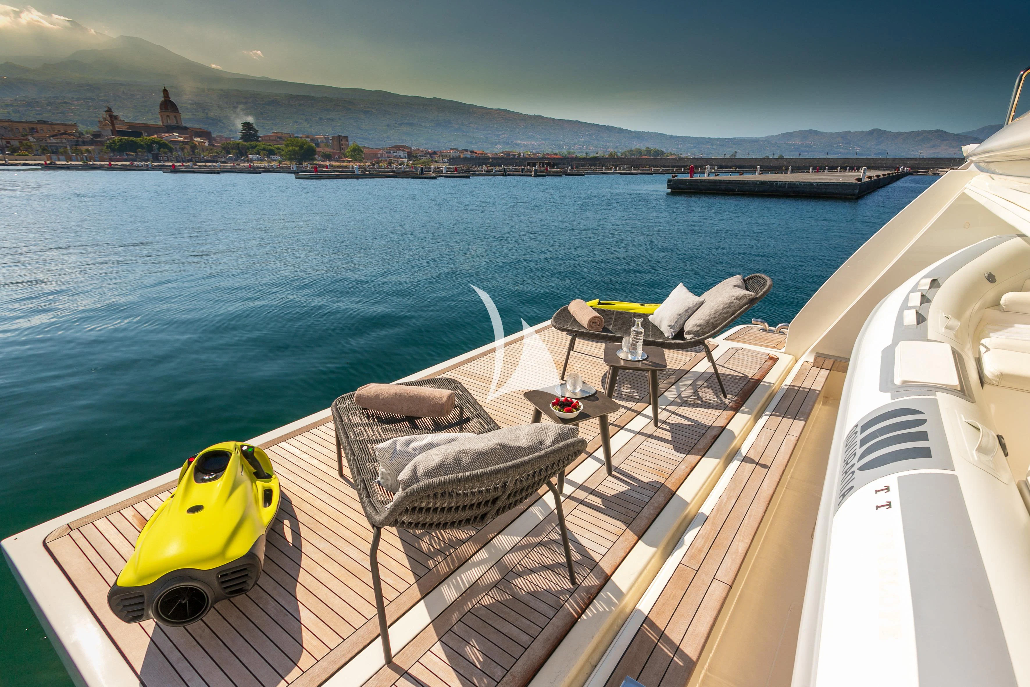 a deck with a chair and a table on it by the water aboard ETHNA Yacht for Sale