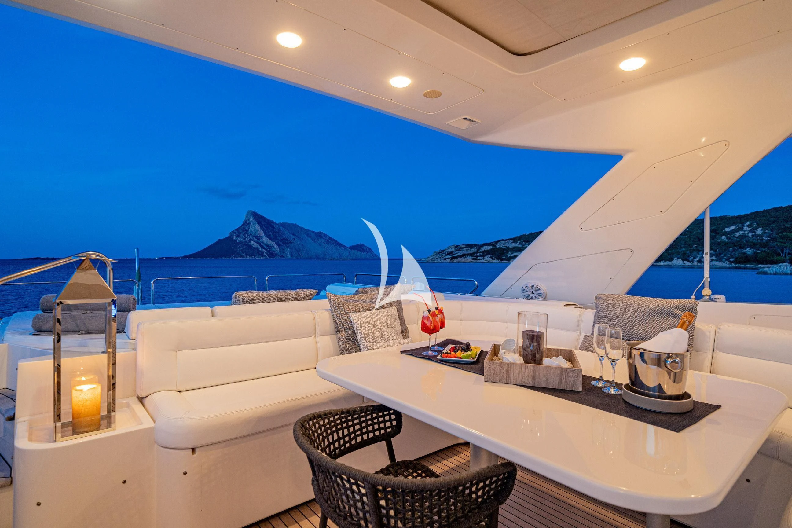a white lounge chair next to a white table with a white table and chairs and a large white aboard ETHNA Yacht for Sale