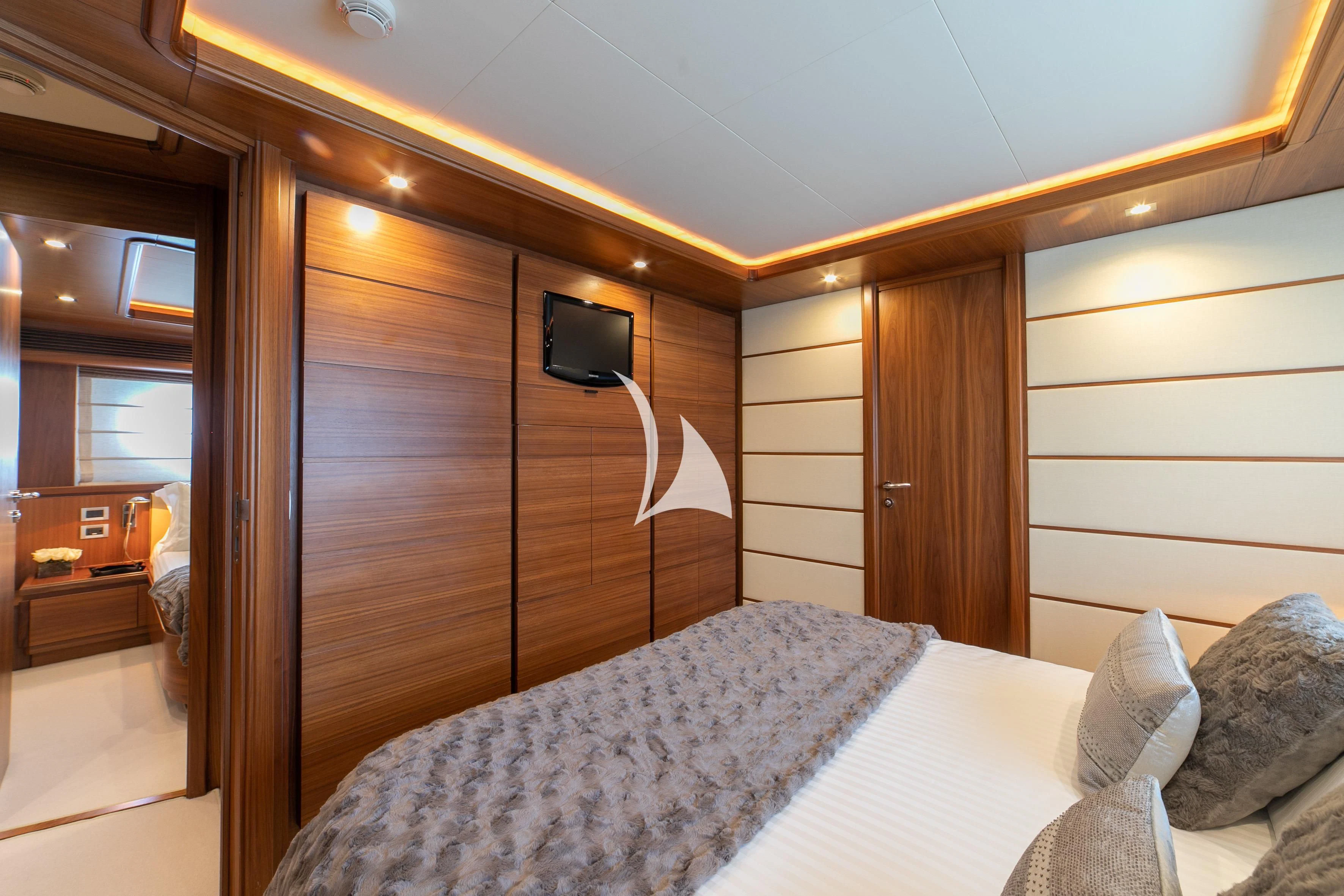 a bedroom with a bed and a television aboard ETHNA Yacht for Sale