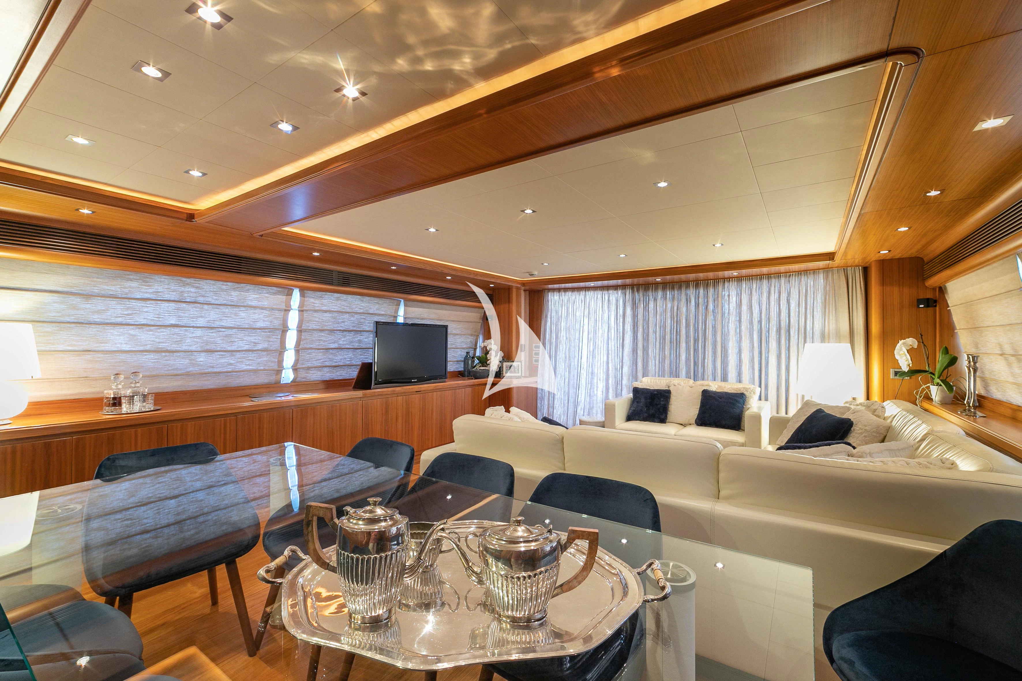 a room with a table chairs and a tv aboard ETHNA Yacht for Sale
