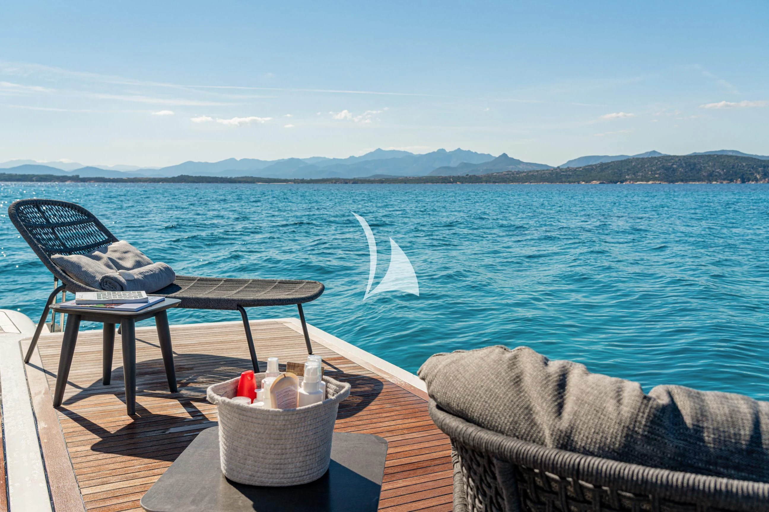 a table and chairs on a deck overlooking a body of water aboard ETHNA Yacht for Sale