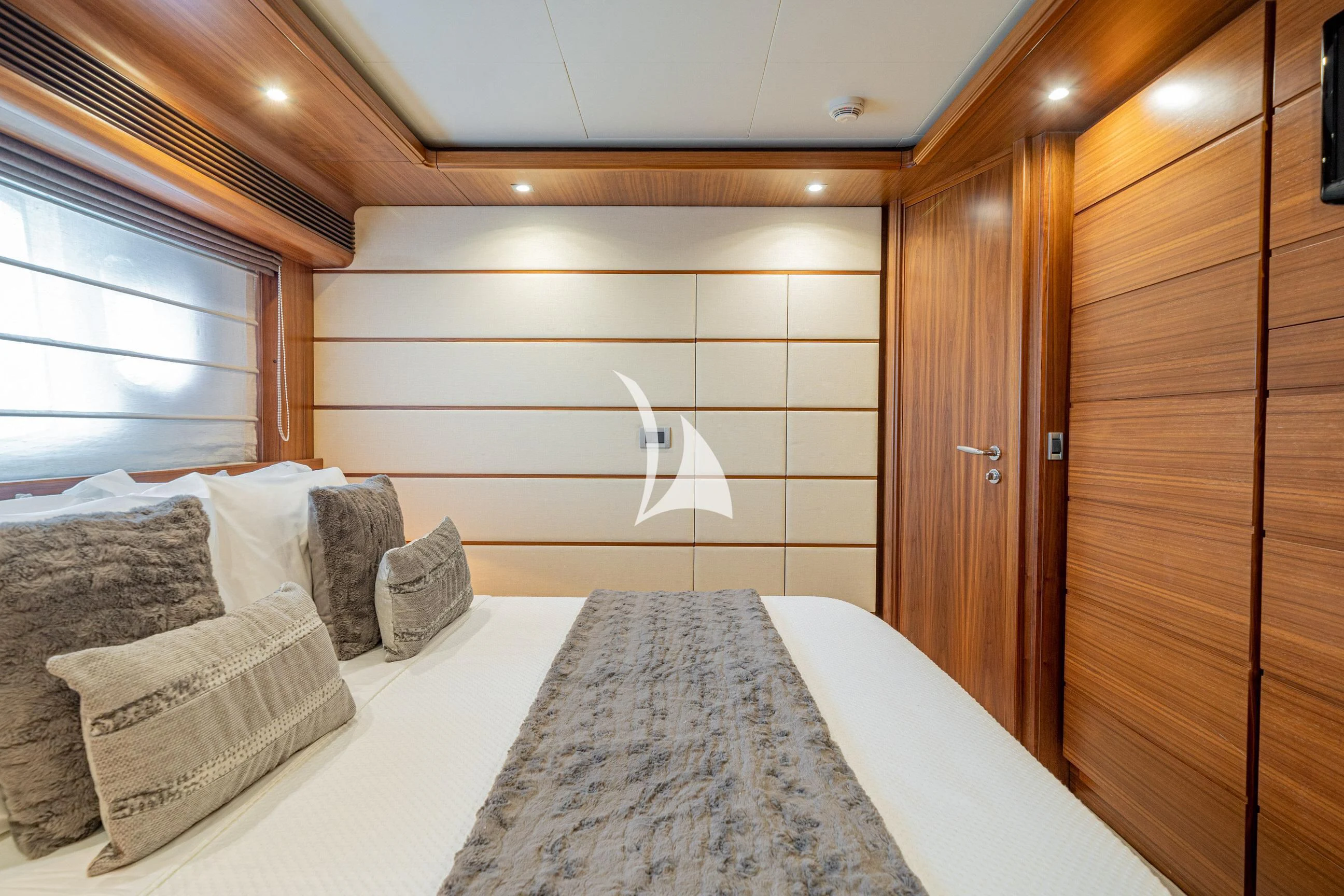 a bed with pillows and a wooden door aboard ETHNA Yacht for Sale