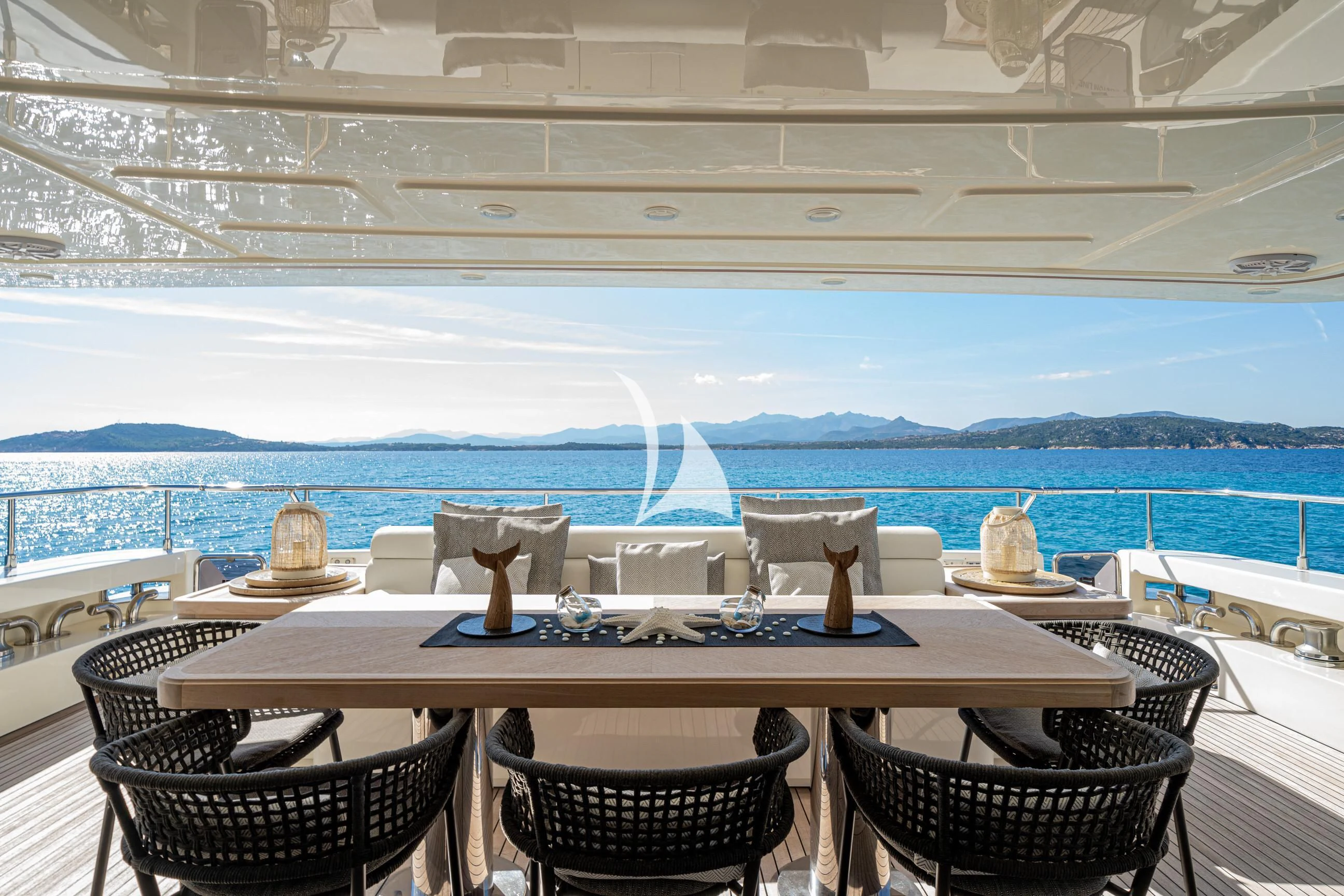 a table with chairs and a view of the ocean aboard ETHNA Yacht for Sale
