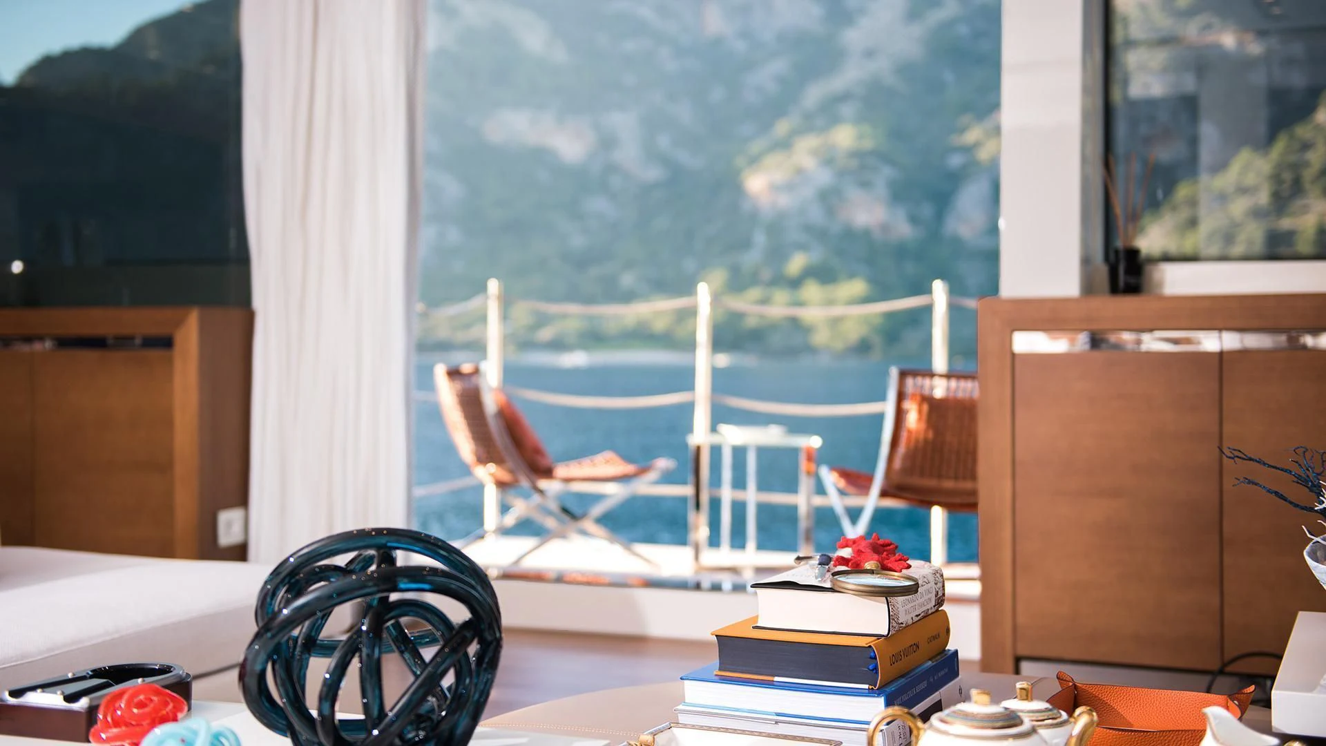 a room with a tv and a table with chairs and a window aboard MORNING STAR Yacht for Charter