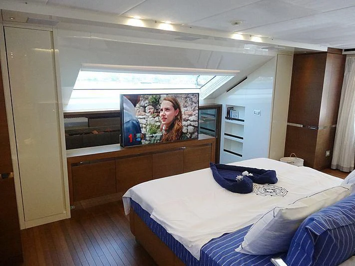 a bedroom with a bed and a television on the wall aboard MORNING STAR Yacht for Charter