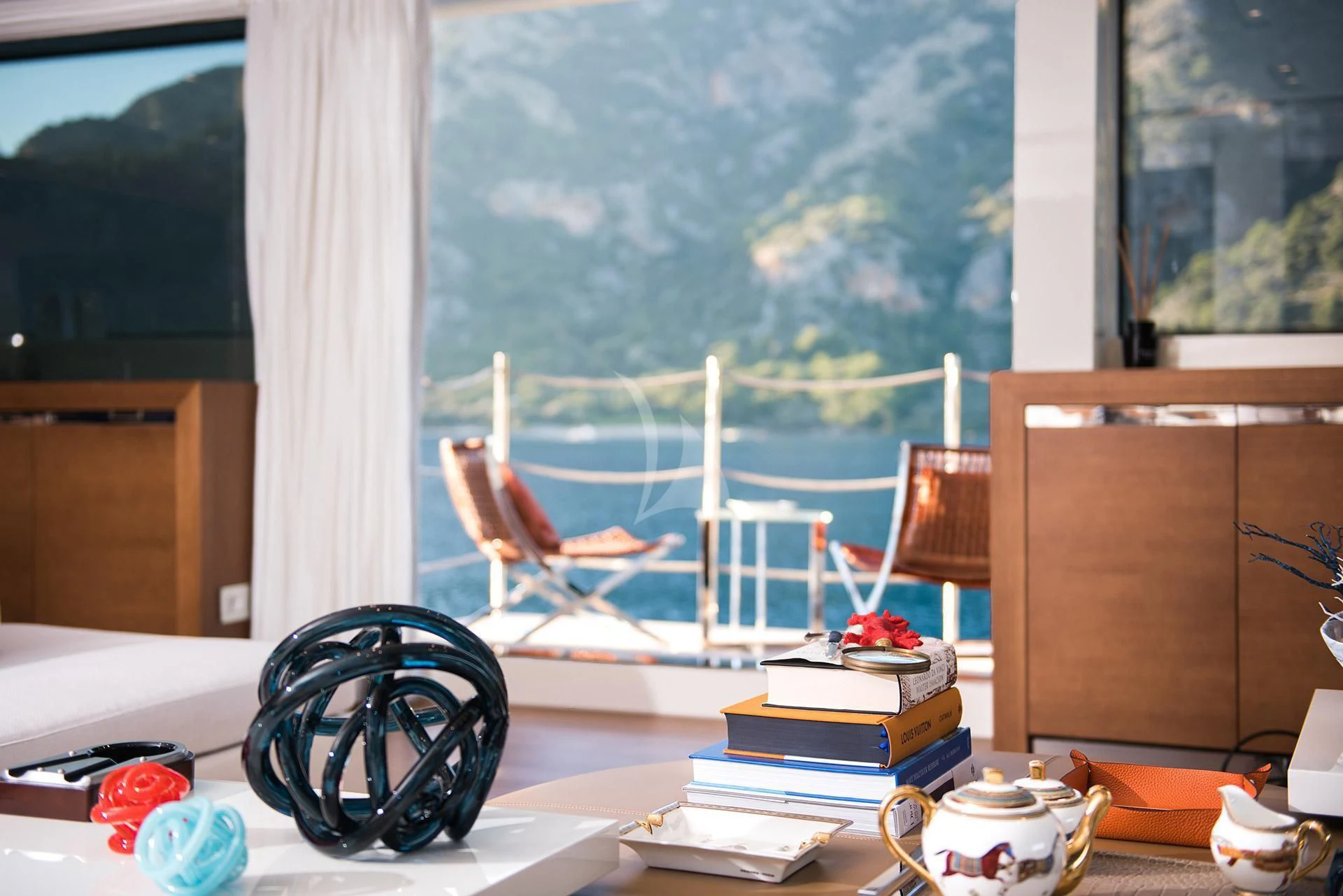 a desk with a computer and a large window with a painting aboard MORNING STAR Yacht for Charter