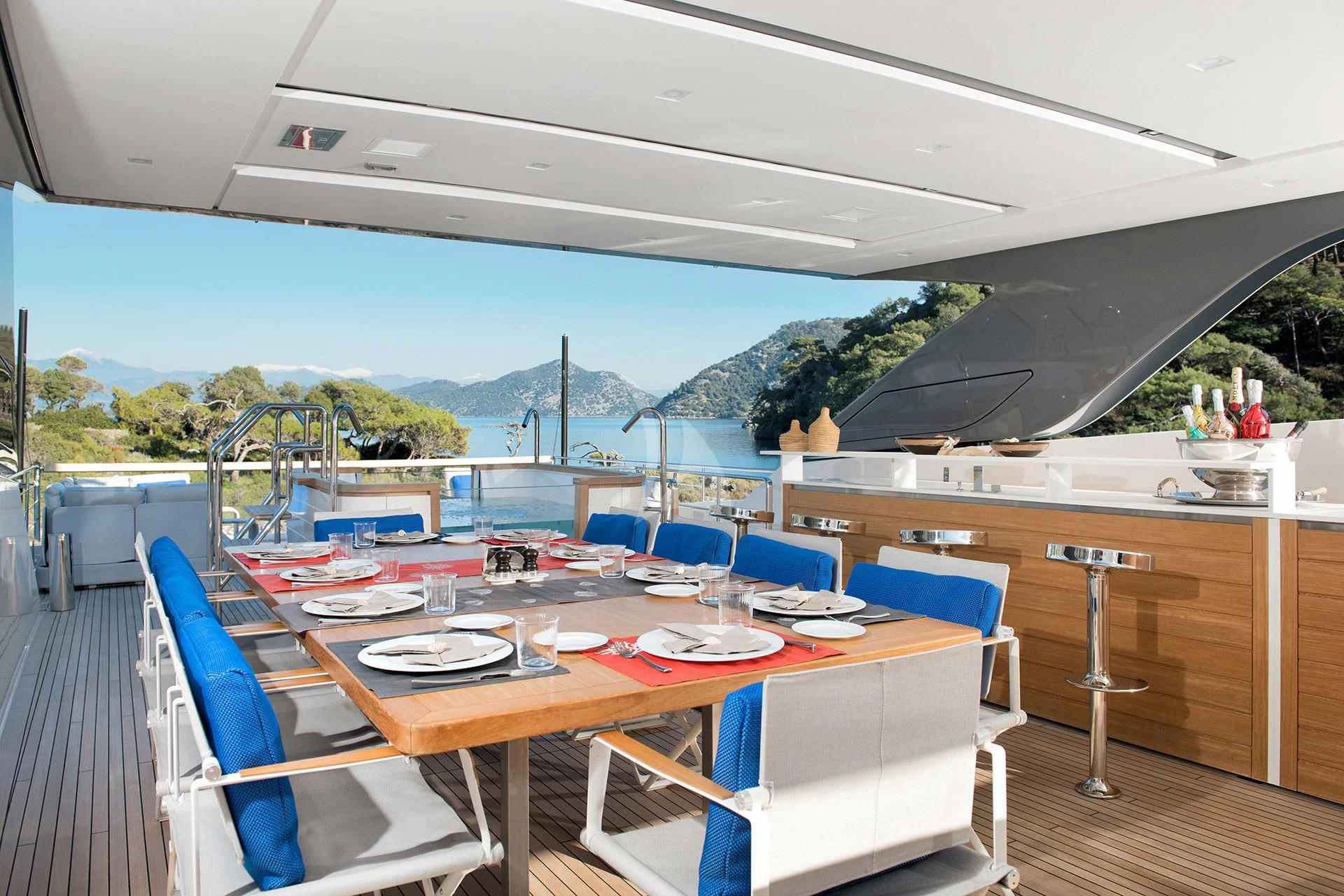 a large outdoor restaurant with a view of the ocean and mountains aboard MORNING STAR Yacht for Charter
