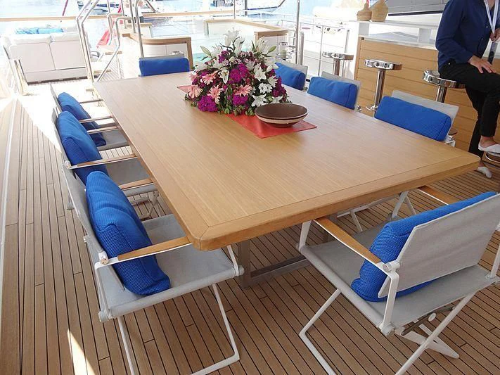 a table with chairs and a vase of flowers on it aboard MORNING STAR Yacht for Charter