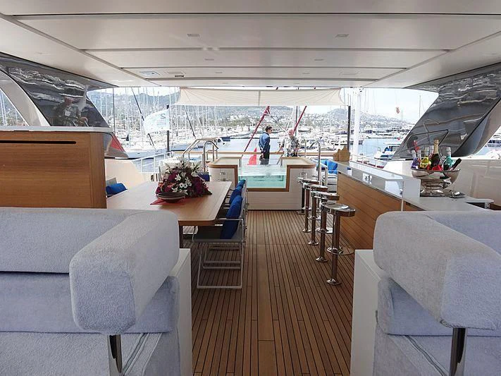 inside of a building with a large open window and a large table with chairs and a person standing aboard MORNING STAR Yacht for Charter
