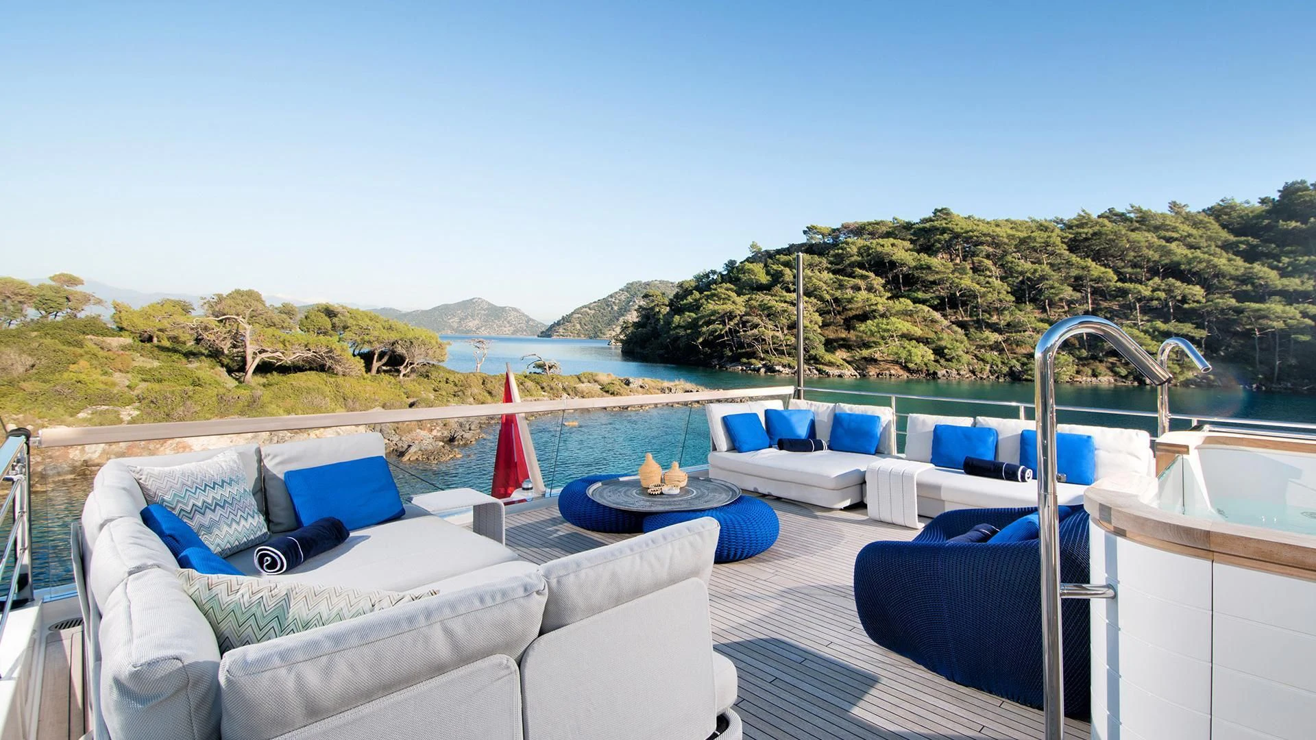 a pool with lounge chairs and a view of the ocean and mountains aboard MORNING STAR Yacht for Charter