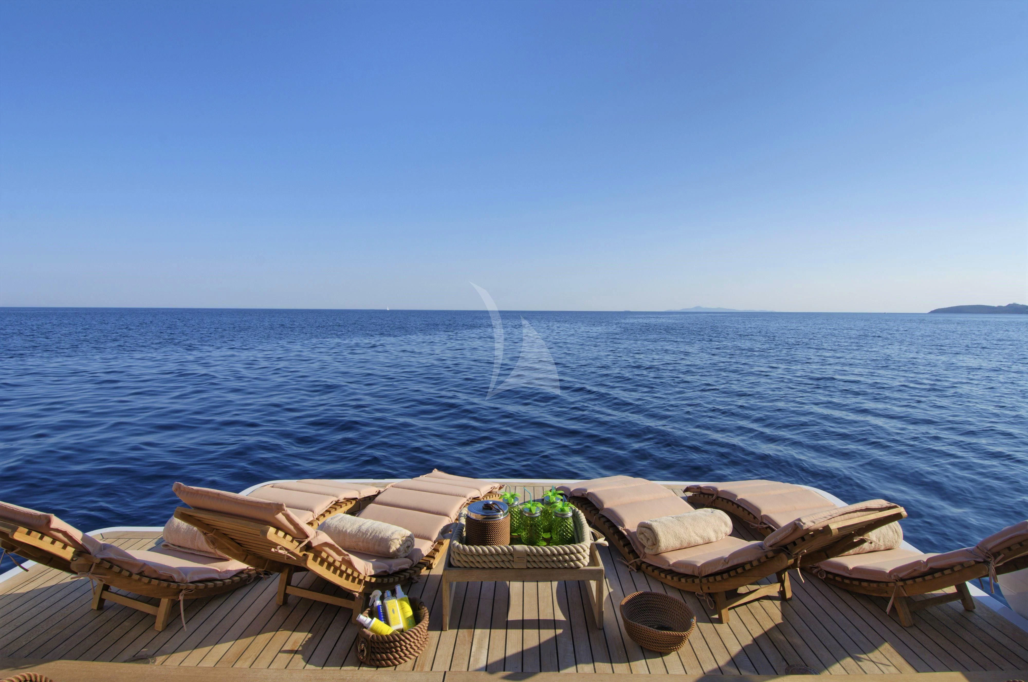 a deck with chairs and a body of water in the background aboard GRANDE AMORE Yacht for Charter
