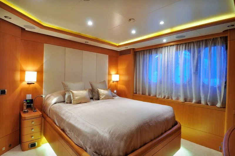a bed with a blue curtain aboard GRANDE AMORE Yacht for Charter