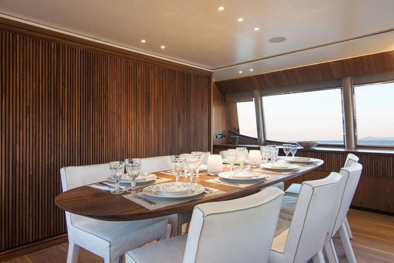 a dining table with wine glasses aboard WHISPER V Yacht for Sale