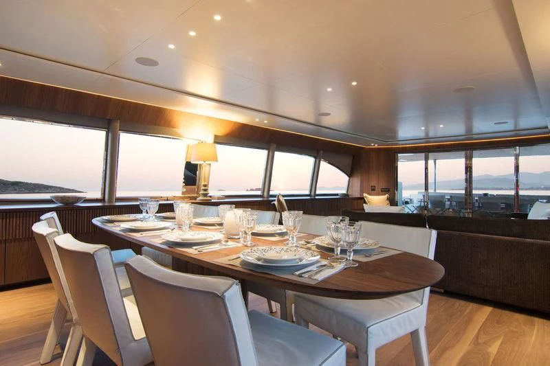 a dining table with glasses and plates aboard WHISPER V Yacht for Sale