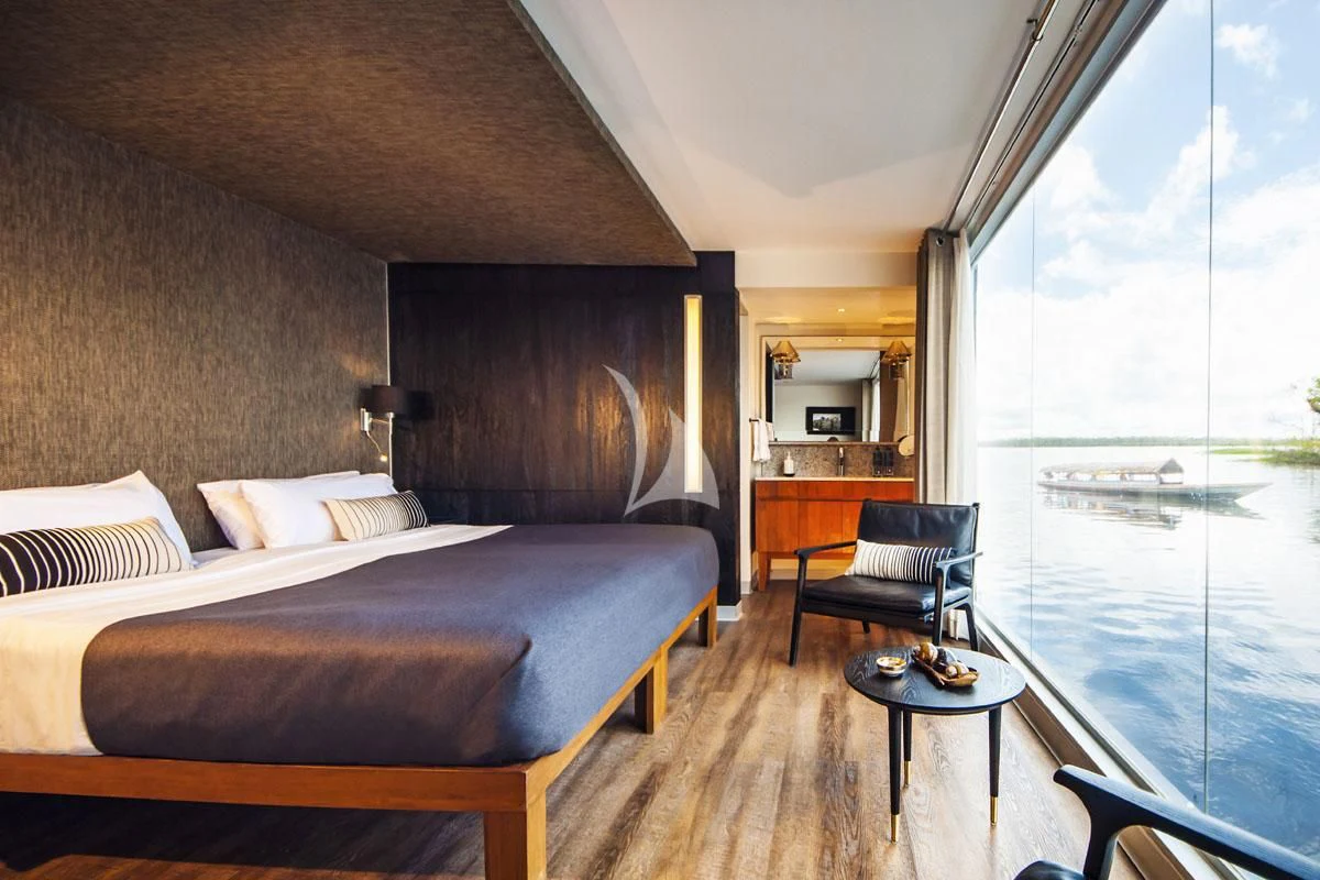 a bed room with a table and chairs aboard ARIA AMAZON Yacht for Sale