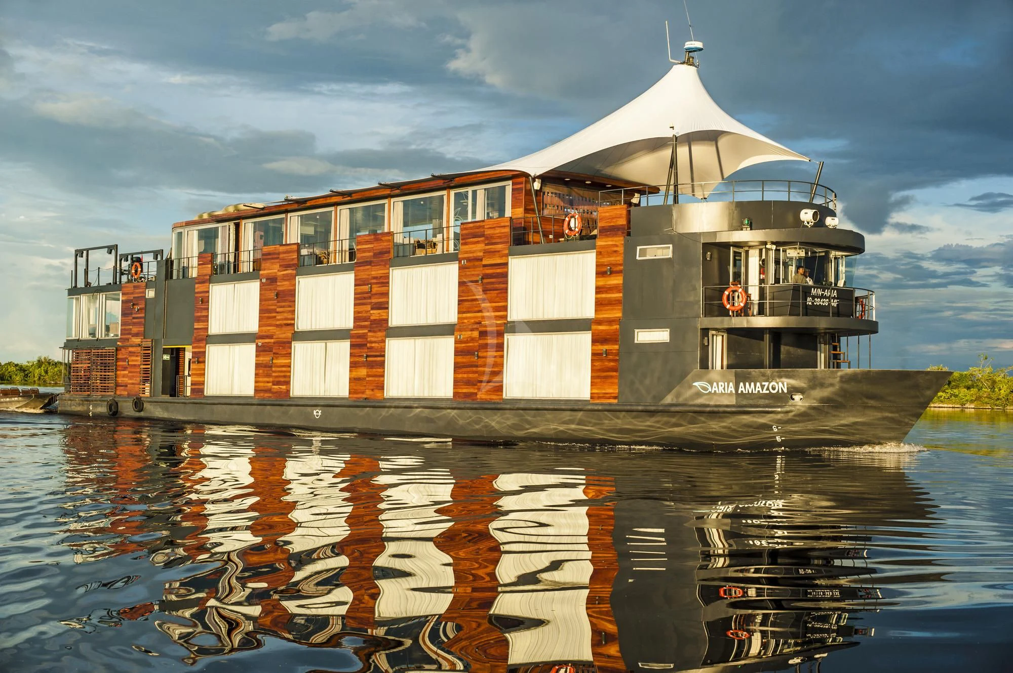 a building with a white awning over water aboard ARIA AMAZON Yacht for Sale