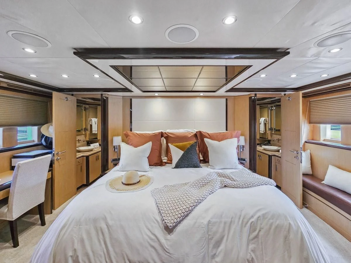 a bed with a white comforter aboard RELENTLESS Yacht for Sale