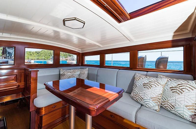 a cabin with a bed and a table aboard RAINBOW Yacht for Sale