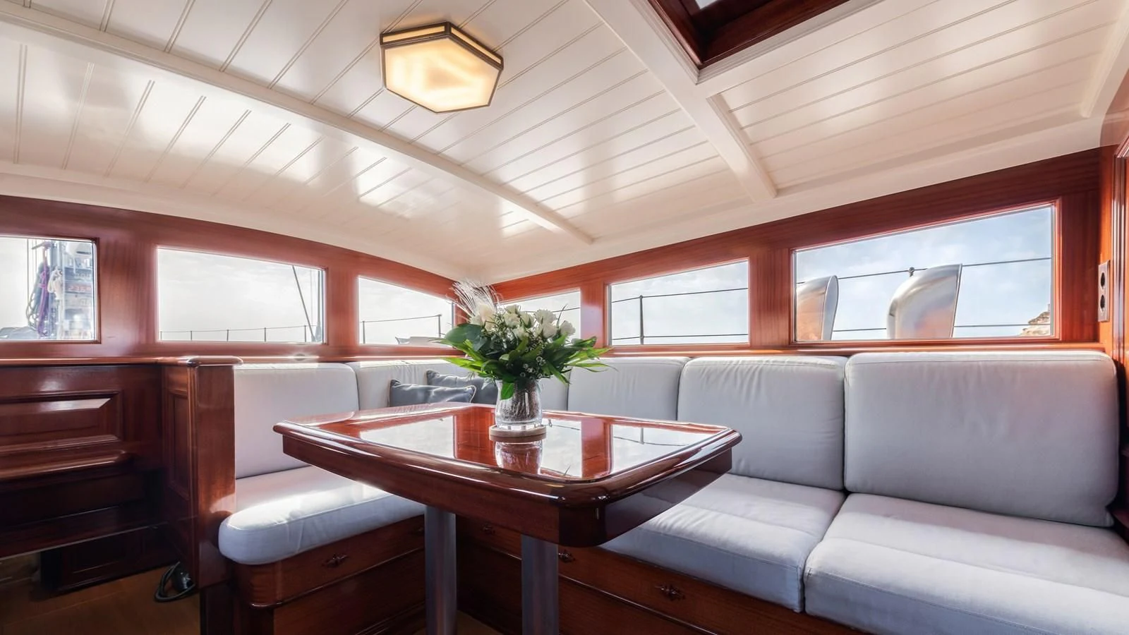 a room with a table and couch aboard RAINBOW Yacht for Sale