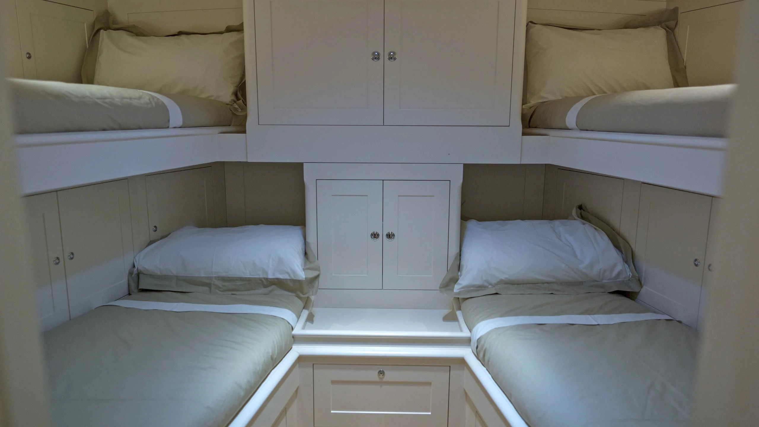 a room with white bedding aboard RAINBOW Yacht for Sale