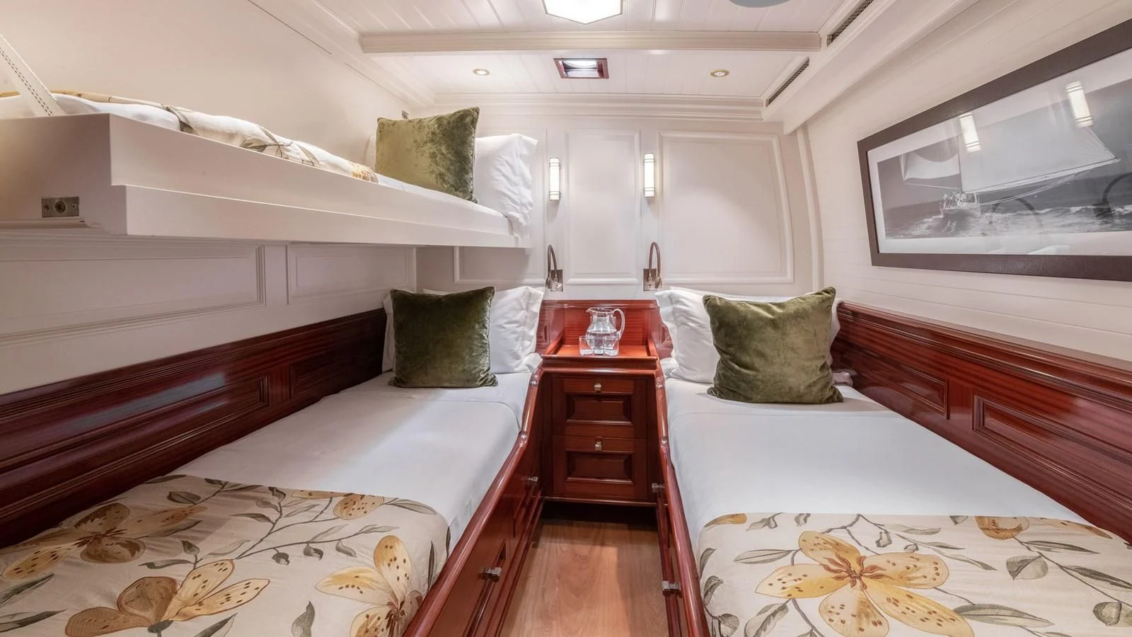 a room with beds and a dresser aboard RAINBOW Yacht for Sale
