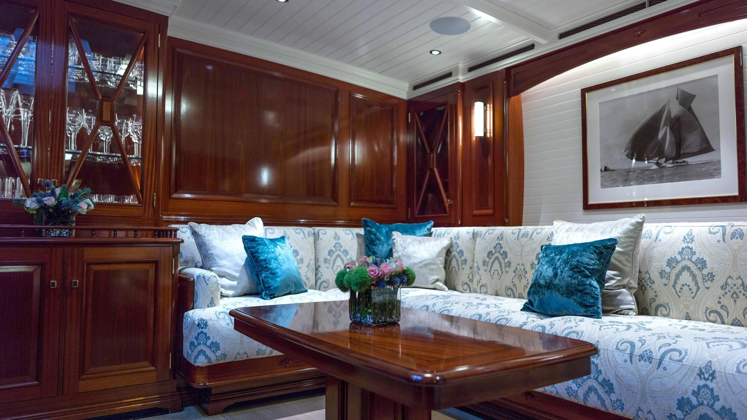 a living room with a white couch and wooden cabinets aboard RAINBOW Yacht for Sale