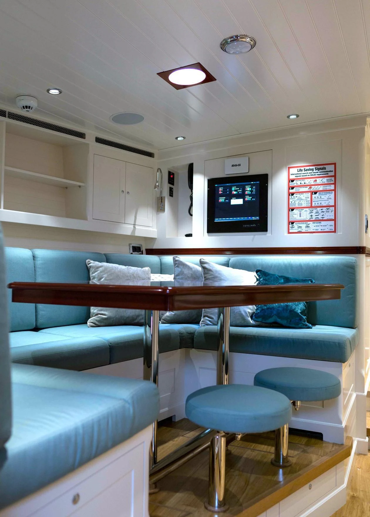 a room with a couch and a tv on the wall aboard RAINBOW Yacht for Sale