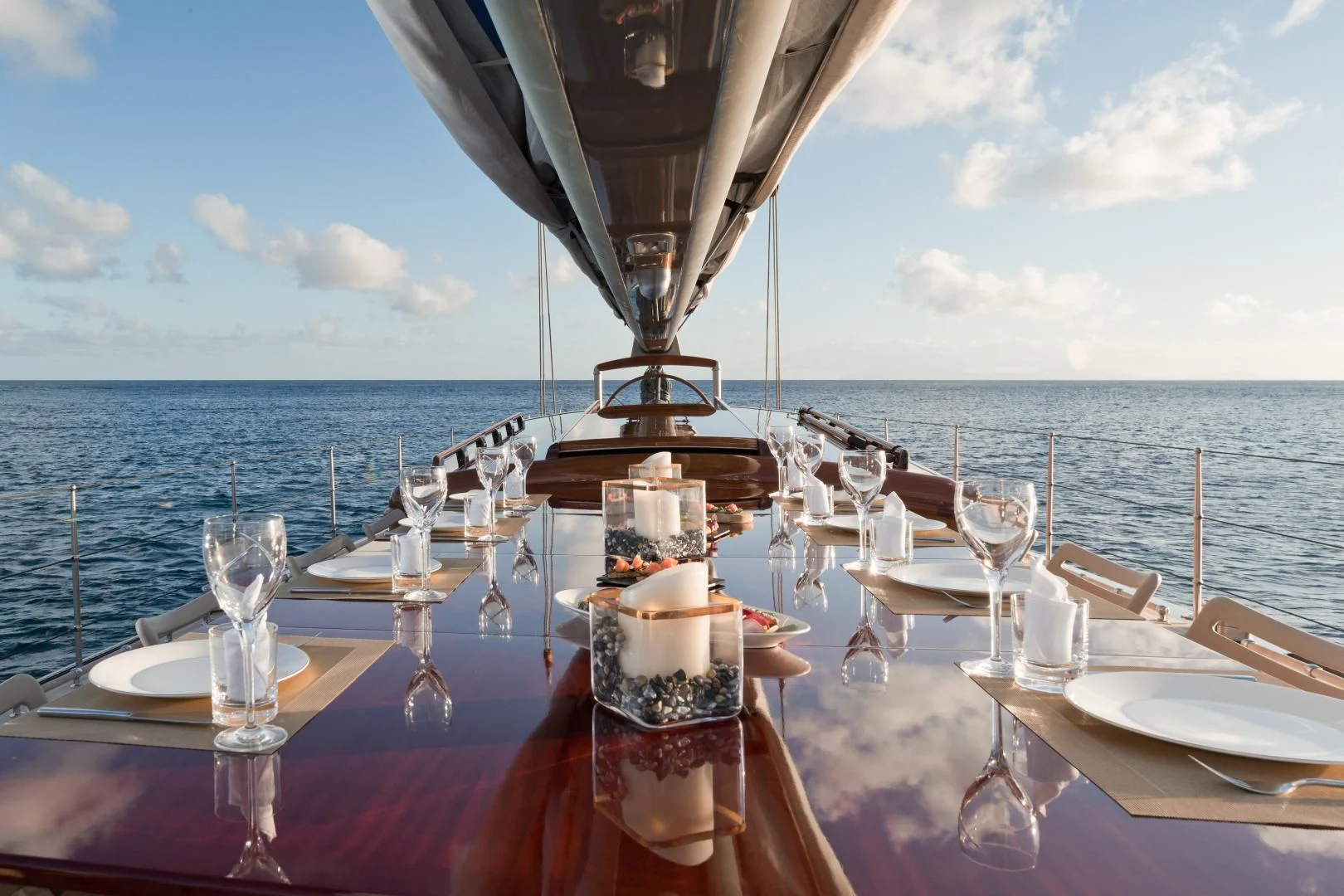 a table with glasses and a view of the ocean aboard RAINBOW Yacht for Sale