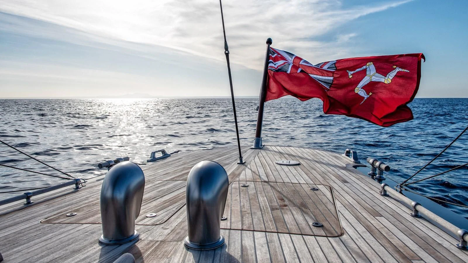 a deck with a flag and a bottle on it aboard RAINBOW Yacht for Sale