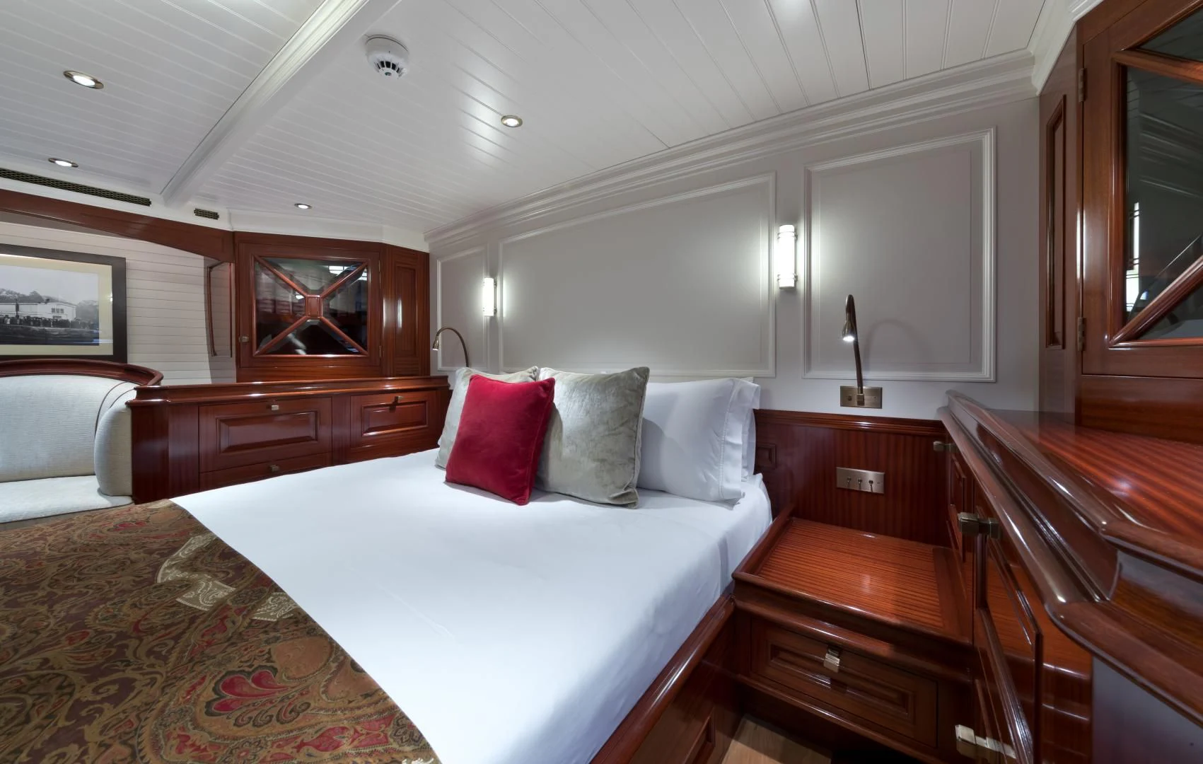a bedroom with a bed and dresser aboard RAINBOW Yacht for Sale