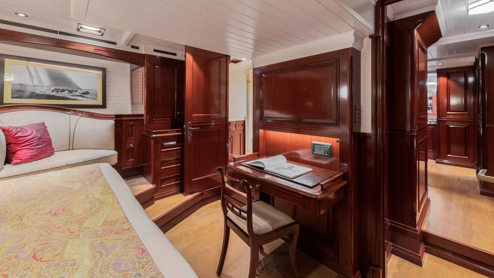 a room with a bed and desk aboard RAINBOW Yacht for Sale