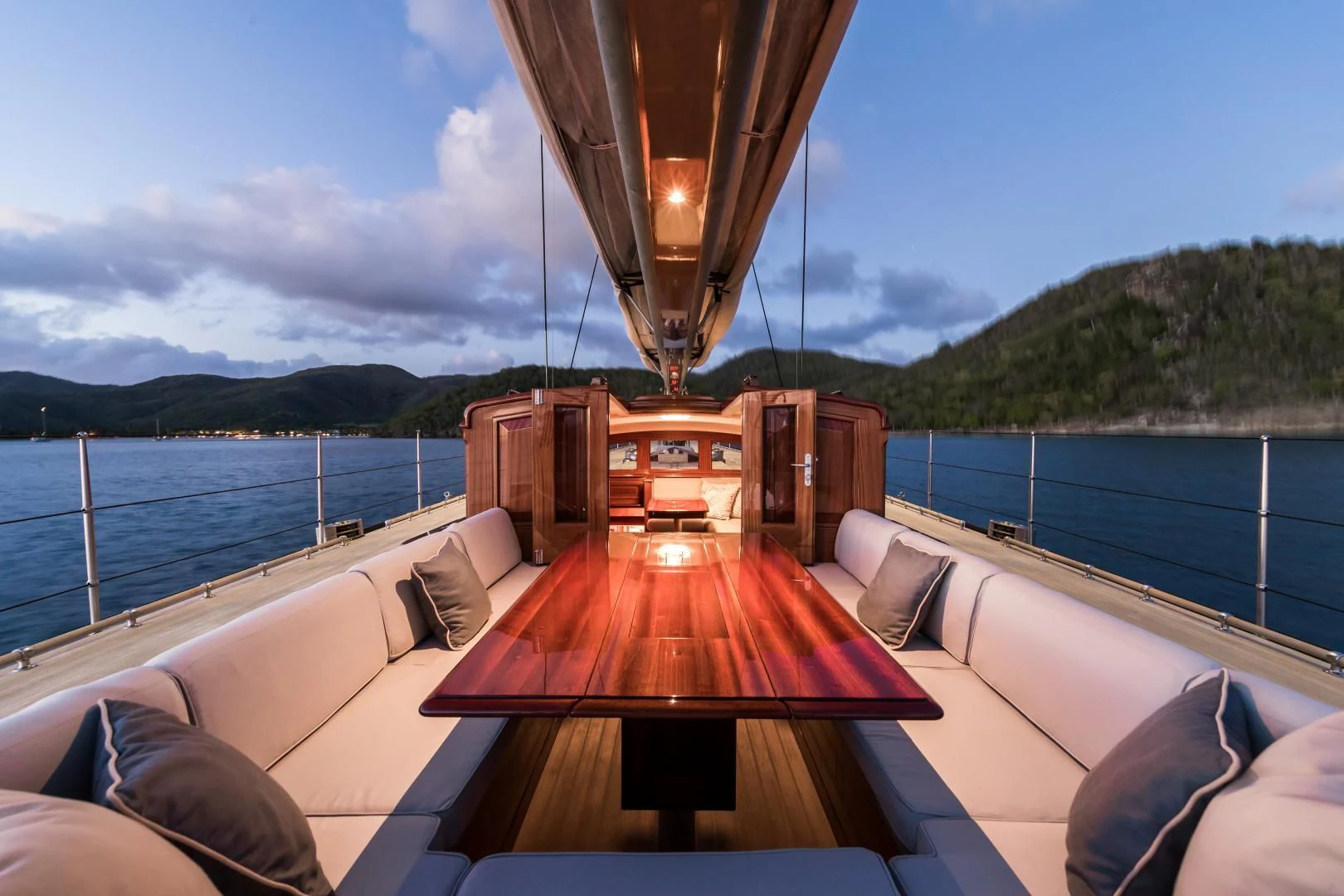 a deck with a wood railing and a large body of water in the background aboard RAINBOW Yacht for Sale