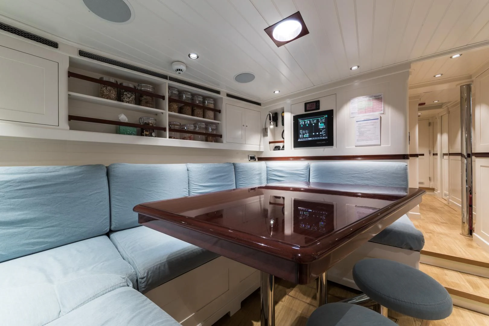 a living room with a table and couches aboard RAINBOW Yacht for Sale